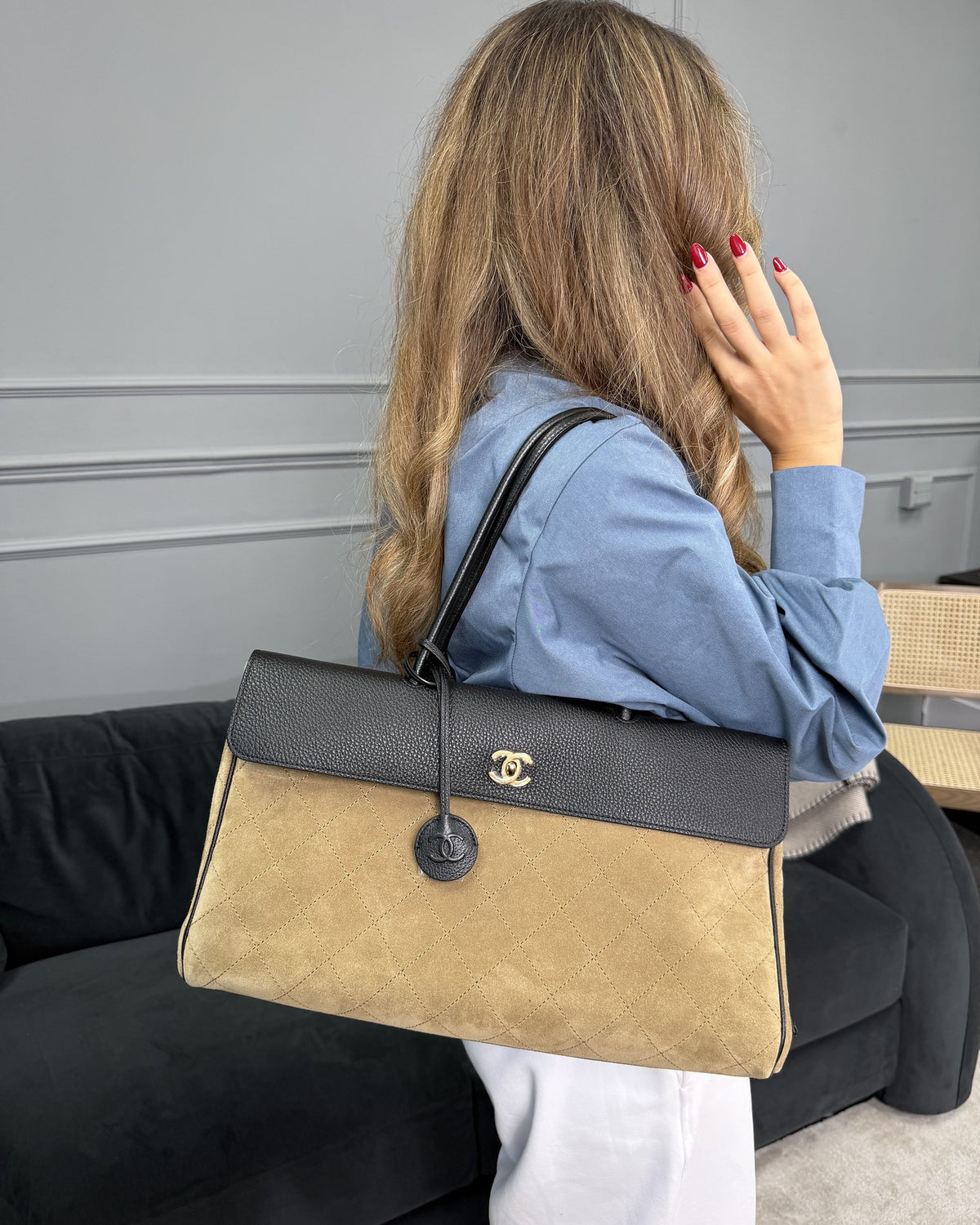 Chanel shopping tote in beige quilted suede and black grained leather, worn on the shoulder