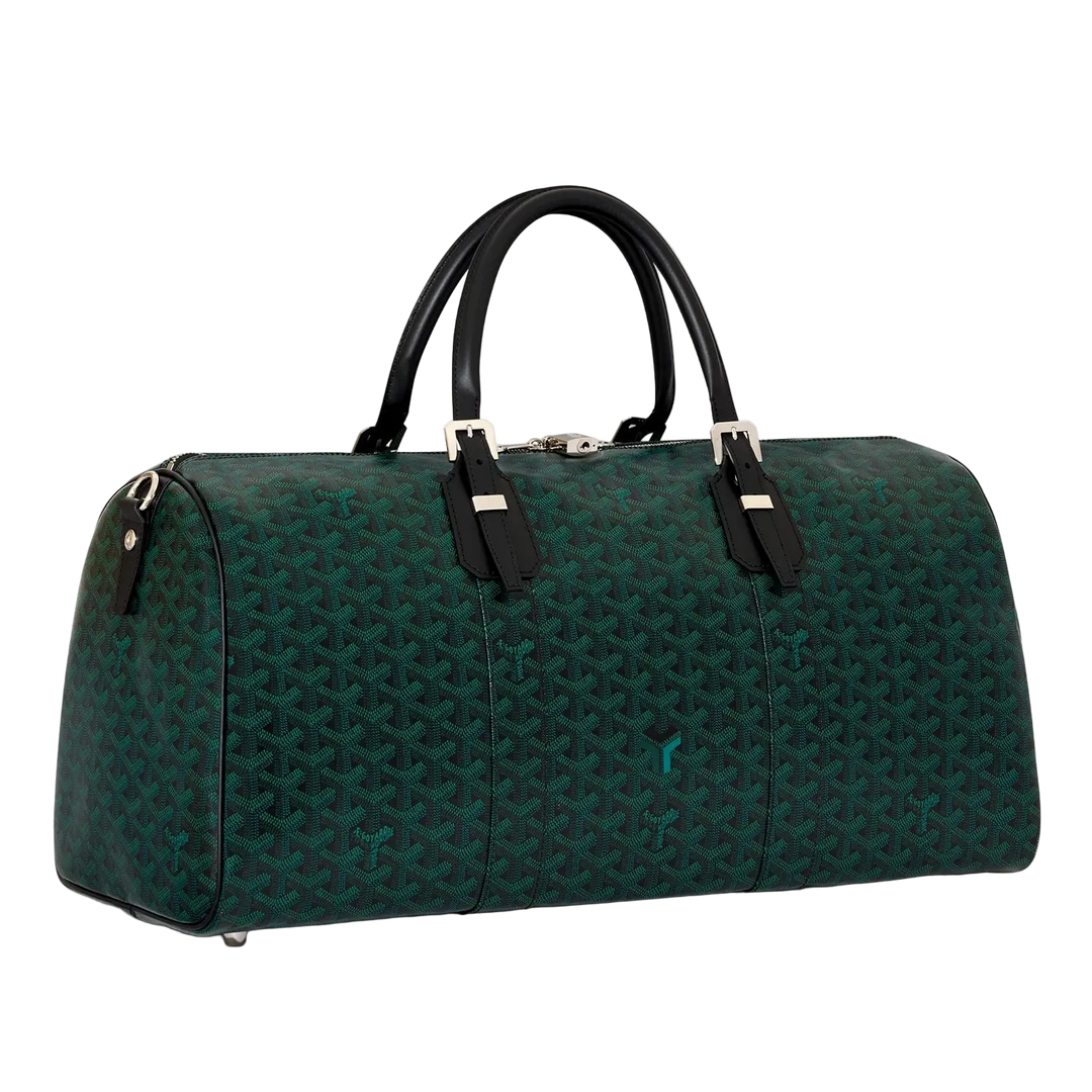 A dark green Goyardine monogram duffel bag with black leather handles and silver-tone hardware, photographed on a clean off-white background.