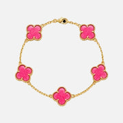 A gold chain bracelet featuring five bright pink clover-shaped charms, each outlined with a textured gold border, displayed on a clean white background.